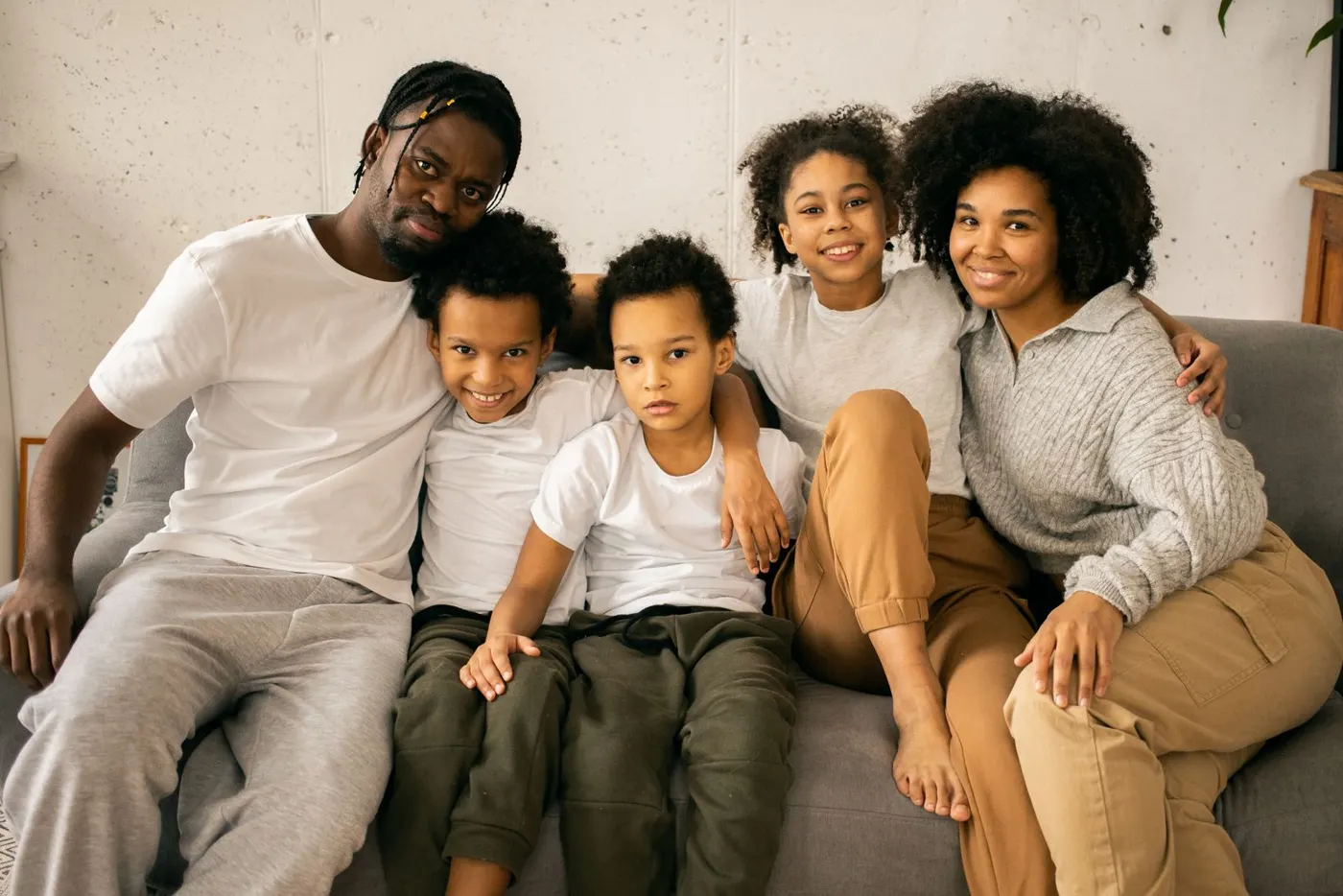 Smiling family of five sitting together on a couch