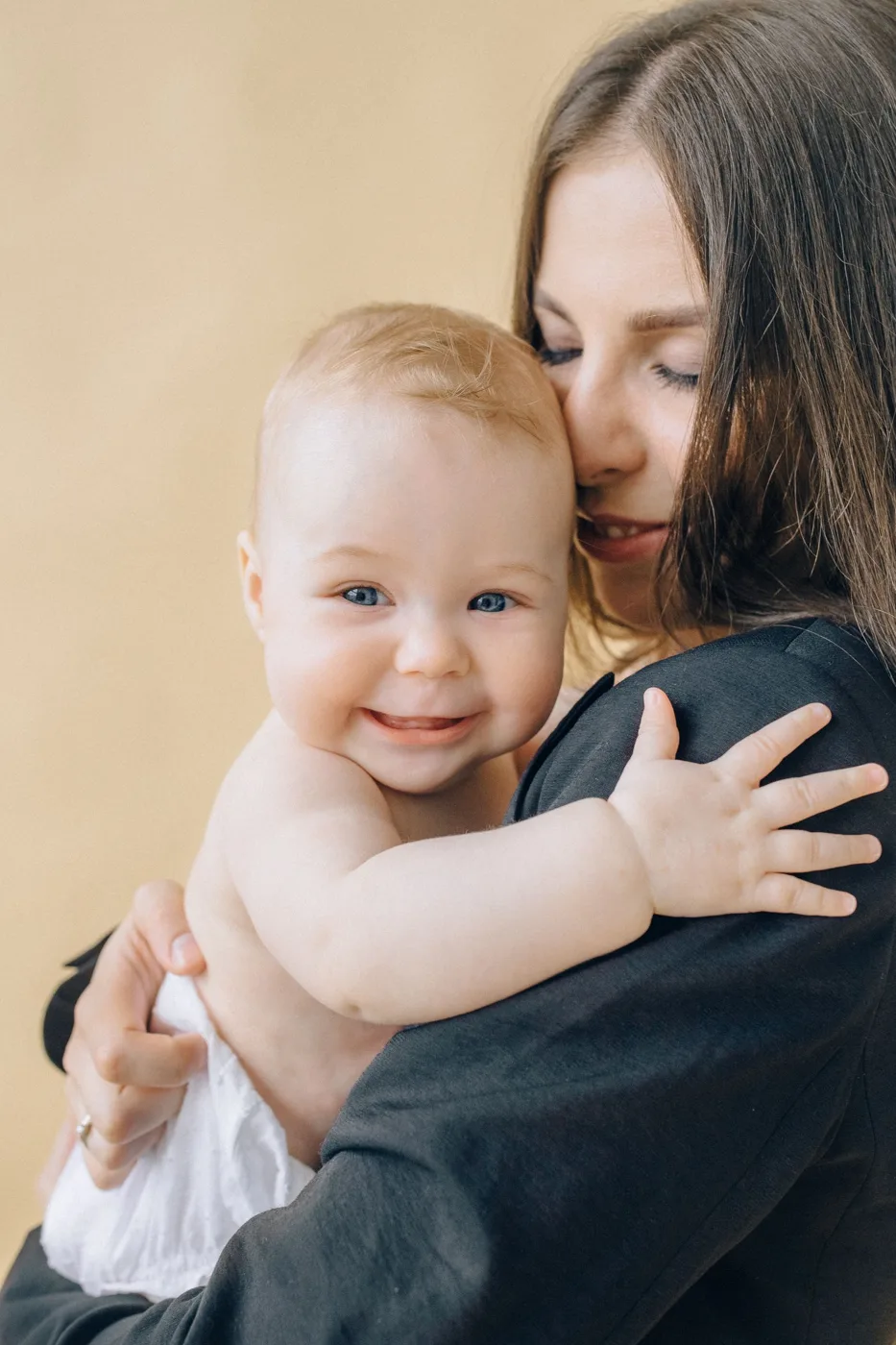 Mother hugging her smiling baby